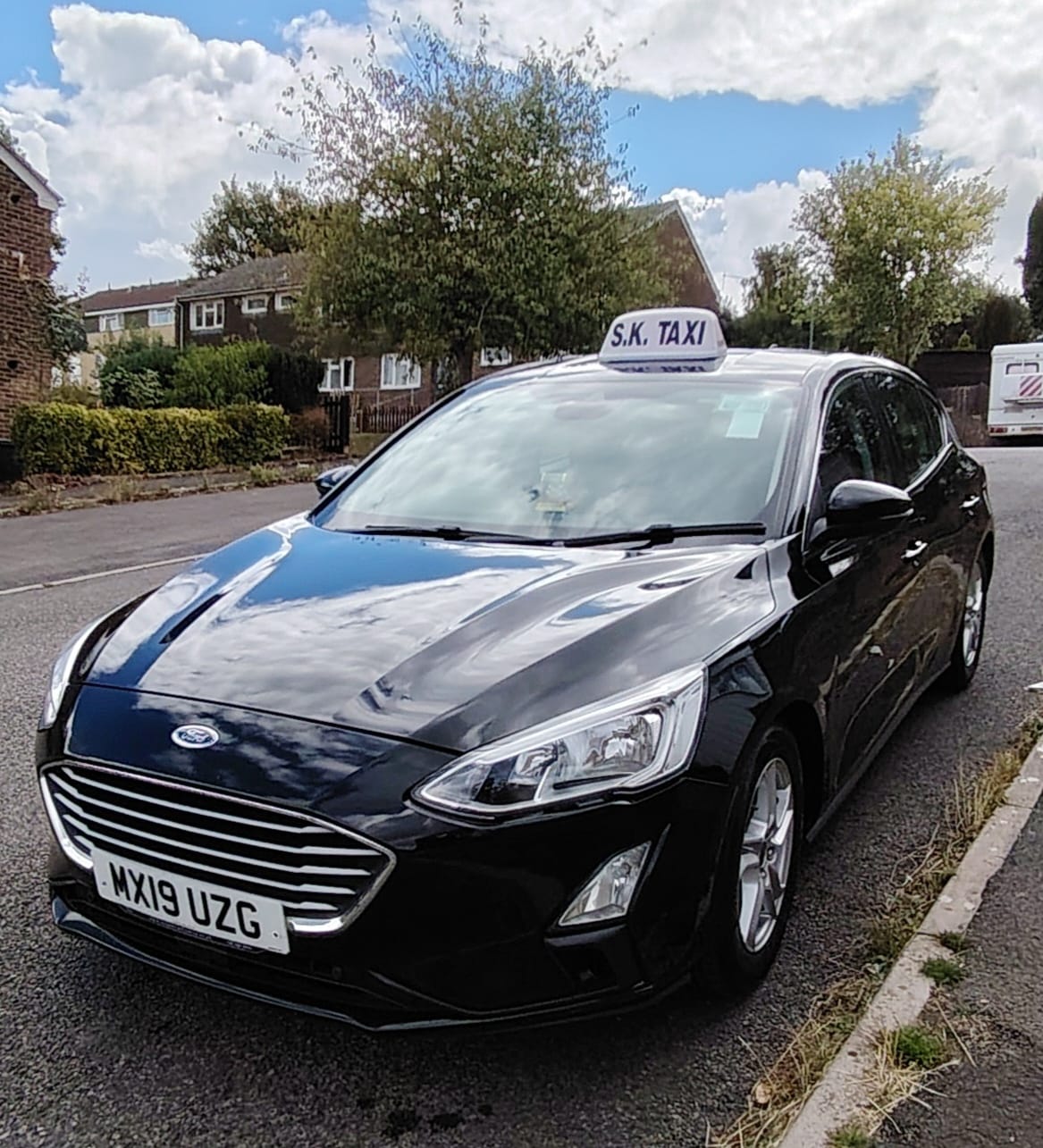 S K Taxis - Black Ford Sedan